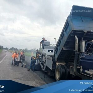 Obreros aplicando asfalto caliente en la autopista de Portuguesa.