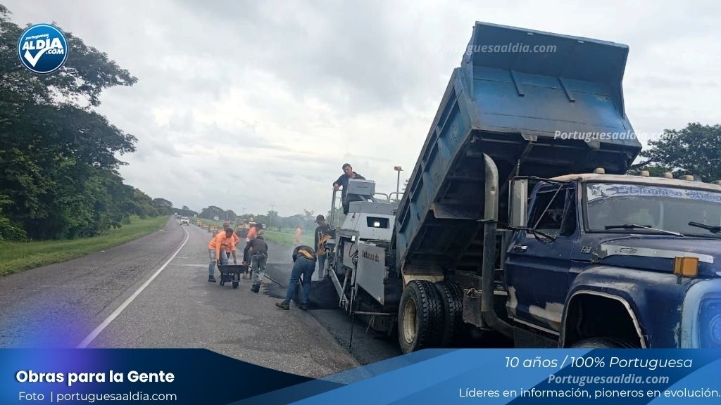 Obreros aplicando asfalto caliente en la autopista de Portuguesa.